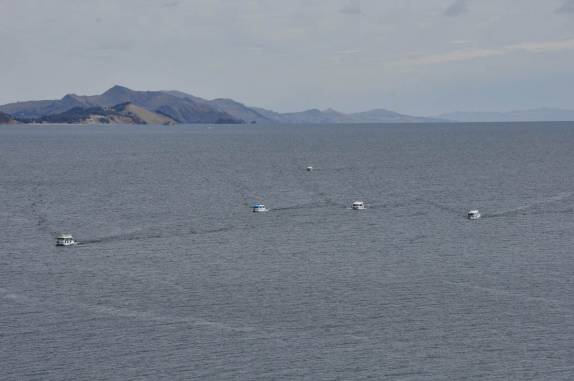 Uma frota de barcos se dirige de Amantani para a ilha de Taquile, no lago Titicaca, no Peru